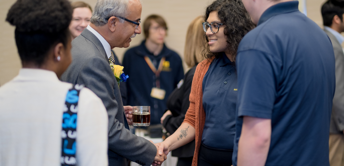 New UM-Flint chancellor Debasish Dutta greets members of the campus community at an event.